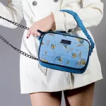 Borsa azzurra in jeans e seta con stampa floreale indossata