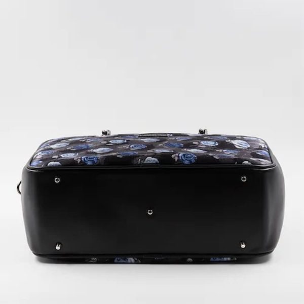Handtasche in Hellblau, Grau und Schwarz aus Seide mit floralem Muster, am Boden.