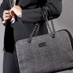 borsa a mano nera e bianca in seta con finiture in pelle indossata