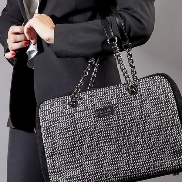 borsa a mano nera e bianca in seta con finiture in pelle indossata