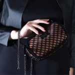 mini borsa in pelle nera e seta con stampa geometrica rossa indossata.jpg