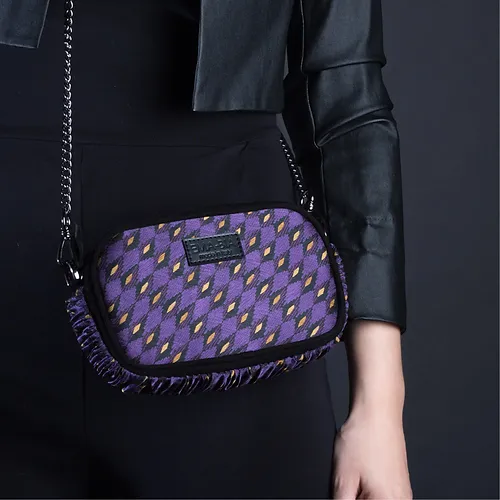 mini borsa in pelle nera e seta con stampa geometrica viola indossata